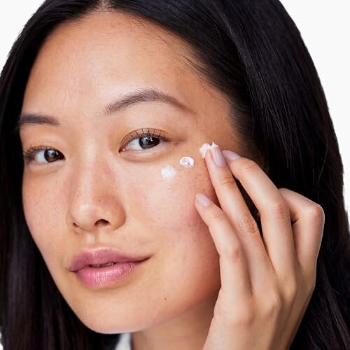 Woman applying skincare cream to her face