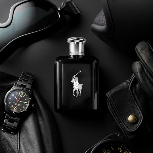 Black cologne bottle surrounded by sunglasses, watch, and leather gloves.
