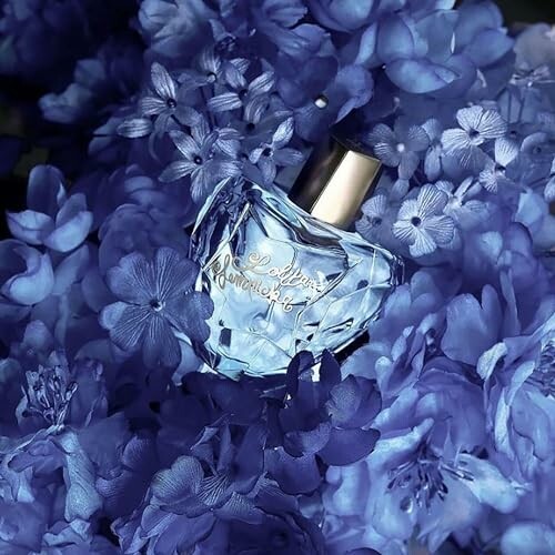 Perfume bottle surrounded by blue flowers