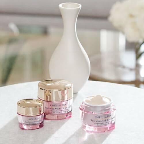 Estee Lauder skincare products on a table with a vase in the background