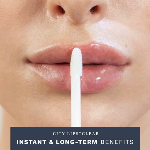 Close-up of a person applying clear lip gloss.