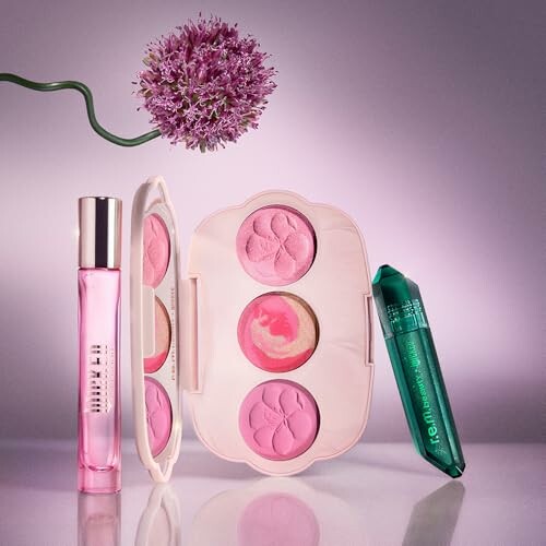 Assorted makeup items with flower and perfume bottle.