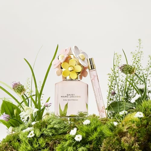 Perfume bottles surrounded by flowers and greenery.