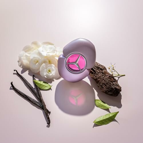 Perfume bottle with white flowers, vanilla pods, and green leaves.