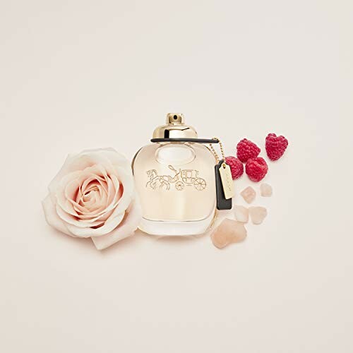 Perfume bottle with rose and raspberries on a light background