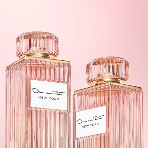 Two elegant pink perfume bottles with ribbed design and gold accents.