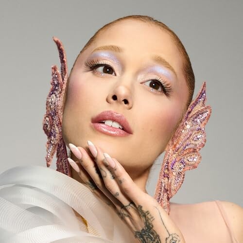 Woman with decorative ear accessories and tattooed hand.