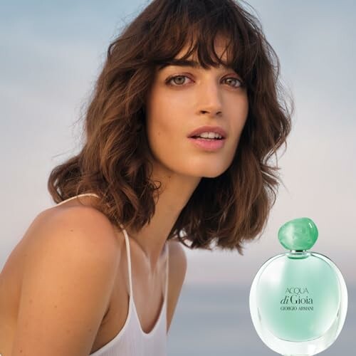 Woman with Giorgio Armani Acqua di Gioia perfume bottle.